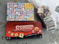Scrabble game box, Flags of the World puzzle box and book, a large bag of stamps and ink pads