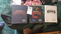 Three baseball card albums displayed side by side, two black featuring San Francisco Giants logos and one white album from 1992 Donruss. Middle album has handwritten labels.