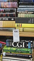 Close-up photo of a shelf displaying hardback books with various colorful spines and titles related to spirituality, psychology, and technology.