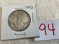 Front view of 1942 Walking Liberty half dollar coin in protective holder with 1942 written on holder.