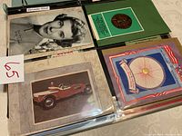 Photo showing a black and white portrait photo of a woman, a red vintage car postcard, and a patriotic themed card with a bicycle wheel emblem.