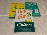 Photo of the three books stacked, showing colorful covers of One Fish Two Fish, Are You My Mother, and Hop On Pop.