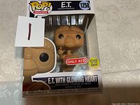 Front view of the E.T. Funko POP! figure in original box, showing the figure, box art, Target exclusive sticker, and glowing heart feature sticker.