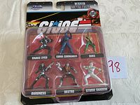 Packaged set of six GI Joe Nano Metalfigs including Snake Eyes, Cobra Commander, Duke, Baroness, Destro, and Storm Shadow with visible character labels and artwork.
