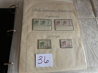 Page with four vintage German stamps from 1935, high denominations with cancellation marks, arranged on cream page inside binder sleeve
