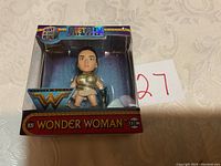 Front view of Wonder Woman heavy die cast metal figurine in original packaging showing figure and box landmarks