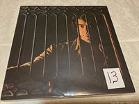 Vinyl album front cover with Neil Diamond portrait behind vertical bars, low light shadows