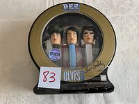 Full frontal photo of sealed Elvis Presley PEZ dispenser set with three figures inside original packaging showing packaging design and collectible stickers.