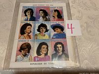 Full sheet of nine Jackie Kennedy stamps in protective sleeve, showing detailed portraits and denominations