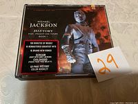 Front cover of Michael Jackson History CD set with promotional sticker detailing contents.