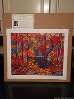 Full view of the large fine art print of a colorful autumn woodland pond scene by Tom Thomson with attached artist bio and label.