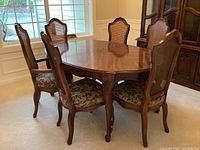 Dining table and chairs arranged, showing wood finish and chair design