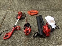 Wide shot showing all three Craftsman tools and an orange extension cord laid out on concrete ground.