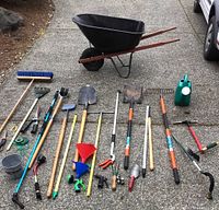 Overview of wheelbarrow and all tools laid out on concrete