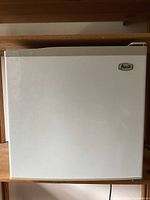 Front view of Avanti mini fridge closed, white with Avanti logo on top right corner.