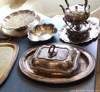 Photo showing the entire silver plated serving ware set including teapot with stand, platters, bowl, and hot dish on large tray.