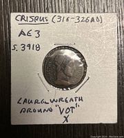 Front side of the ancient Roman coin showing Crispus' profile with laurel wreath and handwritten identification on holder.
