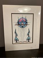 Full view of the print showing the indigenous-themed artwork of mountains, tipi, and trees in muted blue, green, pink, and beige colors framed by a white mat and sealed in protective film.