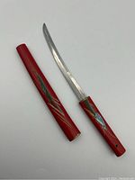 Full view of the 10 inch Japanese Korium letter opener with red lacquered handle and sheath, decorated with fine designs.