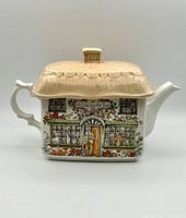 Front side view of Sadler Ye Old Teapot Inn teapot showing detailed painted inn design and thatched roof lid.