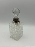 Front angle of the Victorian crystal cruet bottle showing the faceted crystal stopper and sterling silver collar with hallmarks.