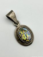 Front angle view of the sterling silver Dragon's Breath pendant showing the iridescent multicolor stone set in silver.