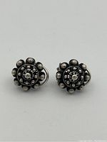Front view of sterling silver floral earrings showing circular bead design.