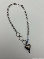 Full necklace showing chain, pendant heart, and blue crystal beads.