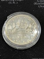 Obverse side of 1961 Canadian 1 dollar coin showing canoe and northern lights design with date 1961.