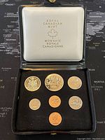 Full view of the Royal Canadian Mint case and all 7 coins displayed on black velvet.