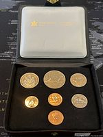 Set of seven Canadian coins from 1980 presented in black cushioned case inside a transparent plastic cover with Royal Canadian Mint logo.