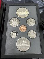 Photo of the front face of the coin set showing all seven coins in proof condition including the two-dollar train coin and the one-dollar skyline coin.