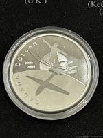 Obverse side of the 2009 Canadian silver proof dollar coin showing skiing figure, aircraft silhouette and denomination details.