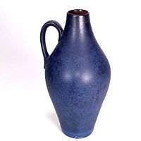 Front view of a tall West German pottery vase with a handle, matte blue speckled glaze.
