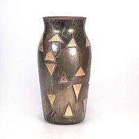 Full front view of the vase showing the incised triangular decorations and metallic glaze.