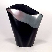 Front view of the asymmetrical postmodern pottery vase with black matte base and metallic silver band at the top edge.