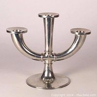 Front view of three-arm modernist Selangor Pewter candelabra showing smooth curves and candle holders.