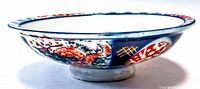 Side view of the antique Imari bowl showcasing hand painted floral and geometric designs with rich blue, red, yellow and gold details.