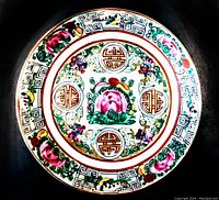 Front side of the antique Asian rose medallion pattern plate showing detailed floral and geometric decoration with vibrant colors and gold accents.