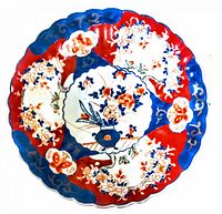 Top view of the antique Imari plate showing intricate hand painted floral and geometric designs in red, blue, and gold.