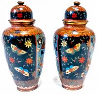 Two vintage cloisonne ginger jars with detailed multicolored butterflies and flowers on black enamel background, copper accents on lids and bases.