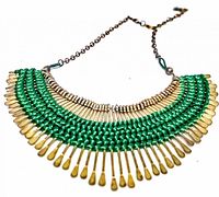 Photo of vintage gold plated threadwork necklace with green thread woven through gold plated metal pins and brass chain.