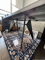 Underside view showing metal V-shaped legs and support frame