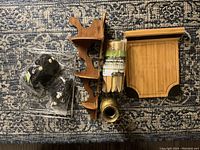 View of boho hanging planter and wooden home and garden items laid out on carpet showing condition and details