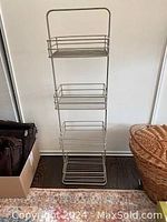Front view of waist high metal caddy with three wire baskets on a stand