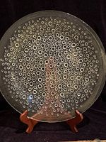 Front view of clear 14-inch glass platter with embedded bubble pattern on wooden stand.