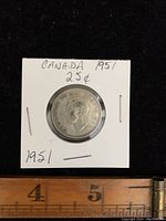 Front side of the 1951 Canadian silver quarter showing King George VI's profile and textual inscriptions.