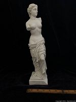 Full view of vintage alabaster Venus de Milo statue showing missing arms and draped cloth design.