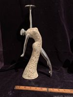 Full frontal view of the Art Deco dancing lady candle holder with a ruler indicating size, showing the figure's pose, resin body and aluminum cast limbs and head.