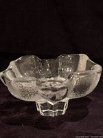 Full view of the clear petal-shaped crystal bowl showing flower-like texture and solid base.